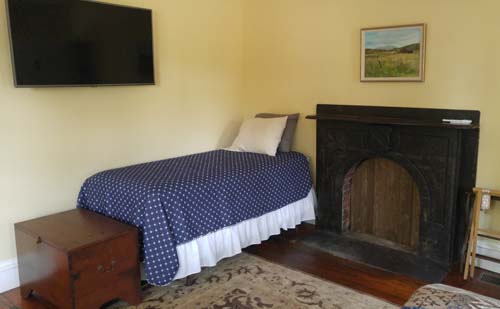 twin bed, wall tv, faux fireplace